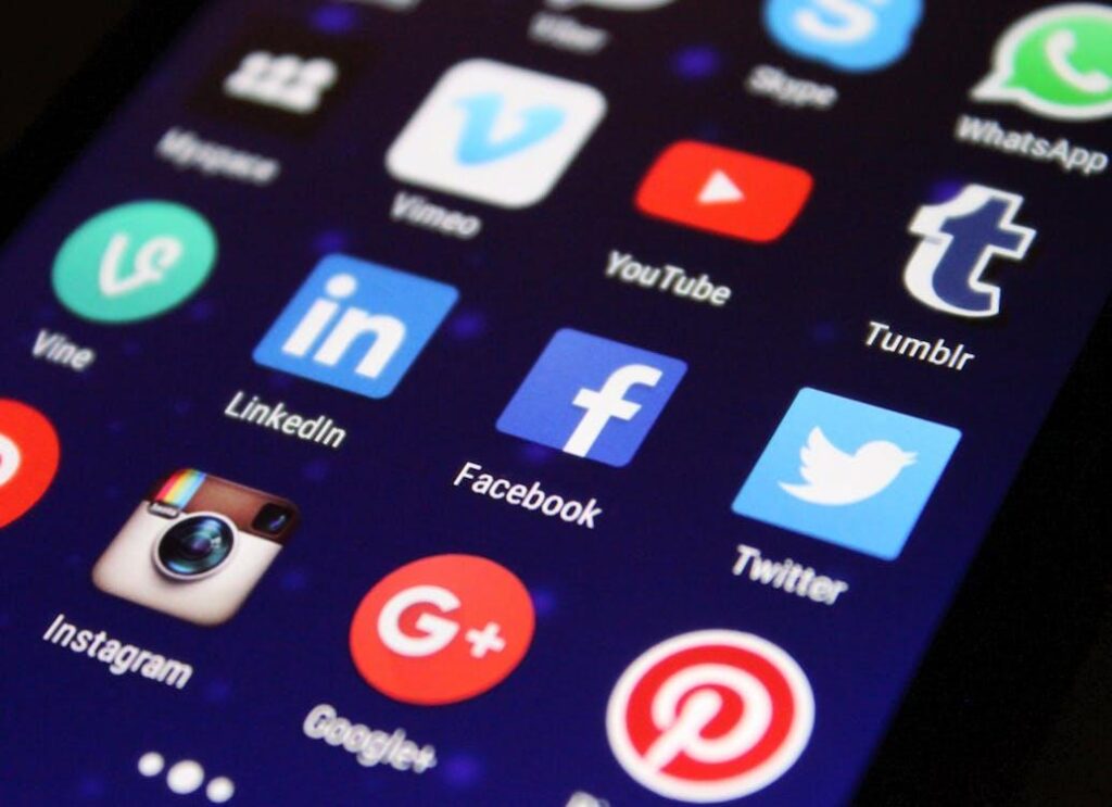 Free Close-up of a smartphone screen showing various social media app icons such as Facebook and Twitter. Stock Photo